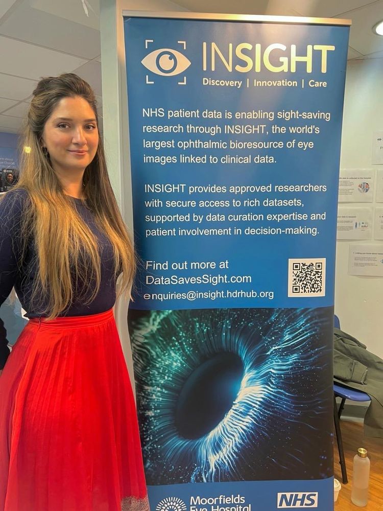 Tara Lee from the Open Data Institute and INSIGHT's Data Trust Advisory Board stands beside the INSIGHT banner at the entrance to the exhibition space at Moorfields Eye Hospital