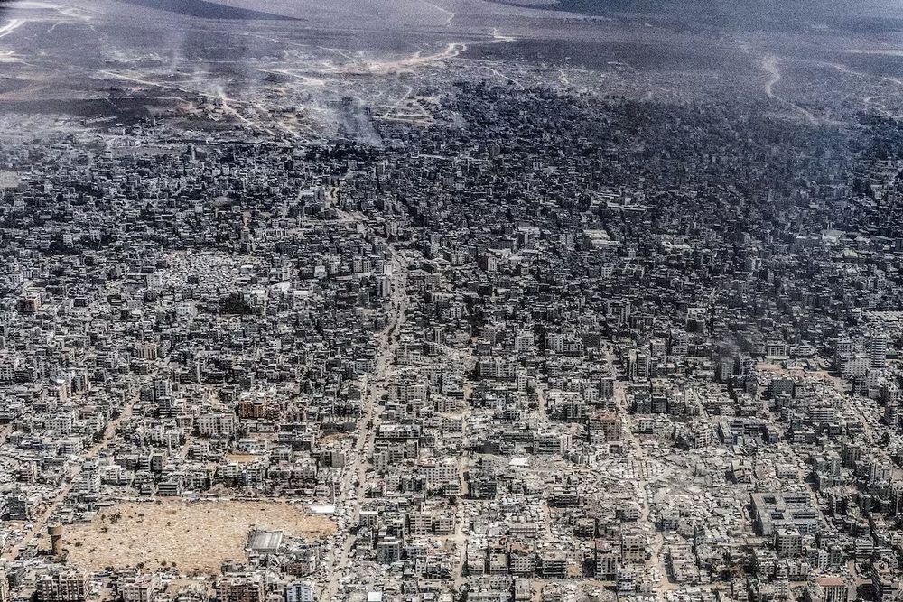 An aerial view of Gaza City taken from a Jordanian military aircraft by photojournalist Heidi Levine in July 2025. Massive destruction is visible, as are IDP tents. 