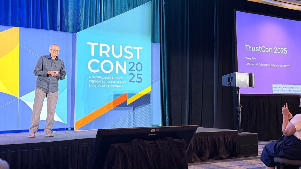 Vinay Rao, ROOST CTO, stands on a stage at TrustCon, giving a presentation.
