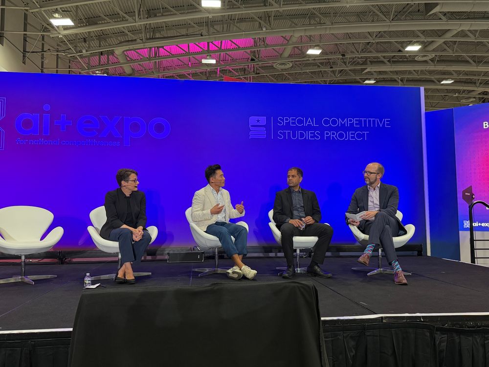 David Chia faces Roblox’s Naren Koneru and Eli Sugarman on stage during the panel with the blue AI+ Expo backdrop behind them. 