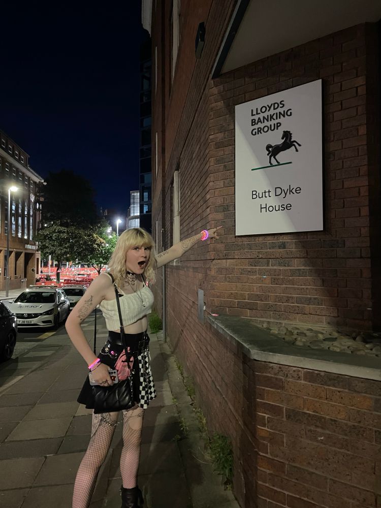Me pointing at a sign labelled butt dyke house