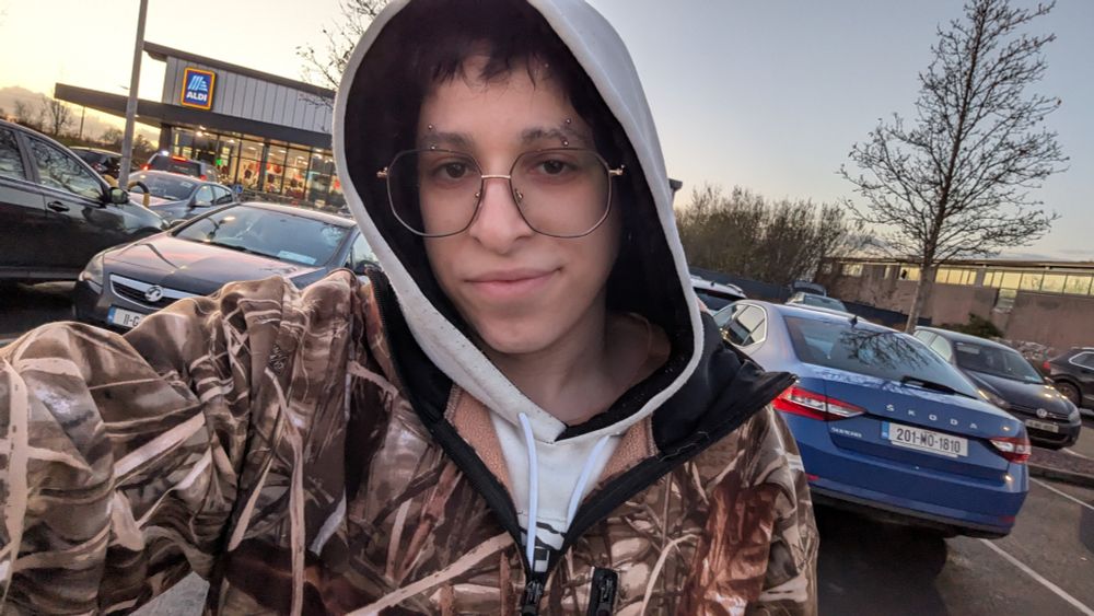 A photo of Sable wearing a hoodie and a camouflage brown jacket