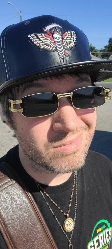 A picture of myself, wearing my Black Craft Cult death head moth hat, a unicursal hexagram pendent, and an ankh.
