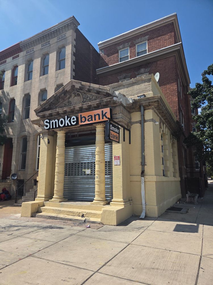 The Smoke Bank in Baltimore- a vape store in a Greek revival form bank buildinf with a sign imitating the Porn Hub logo. 