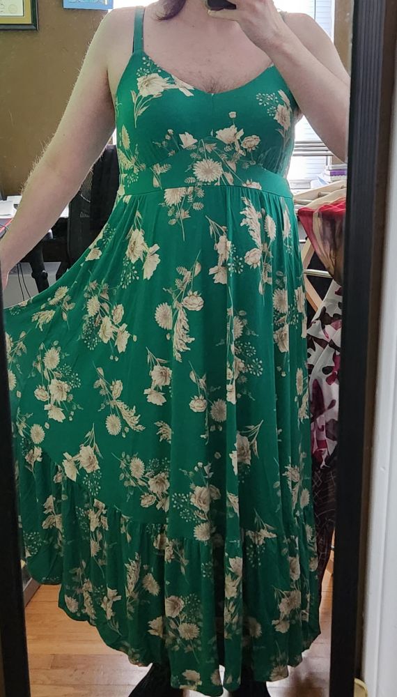 A somewhat tallish person (me!) wearing a long green dress with a light yellow floral print. The picture is only from the shoulders down because i'm mega self conscious, ha
