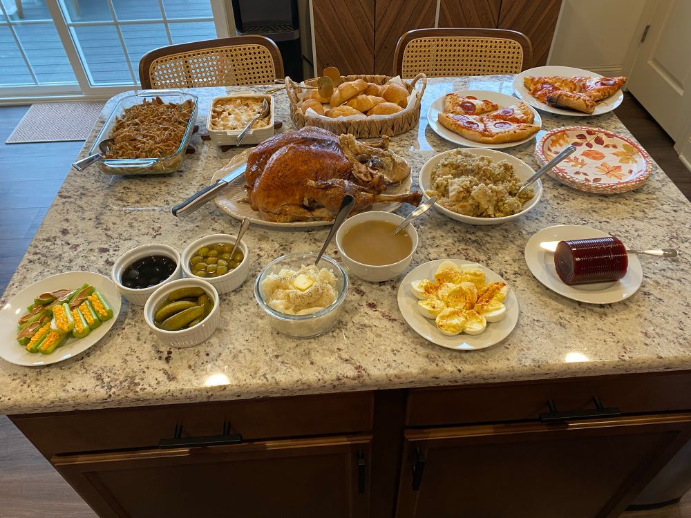 A Thanksgiving spread with turkey, mashed potatoes, green bean casserole and all the fixings, plus pizza for the kids