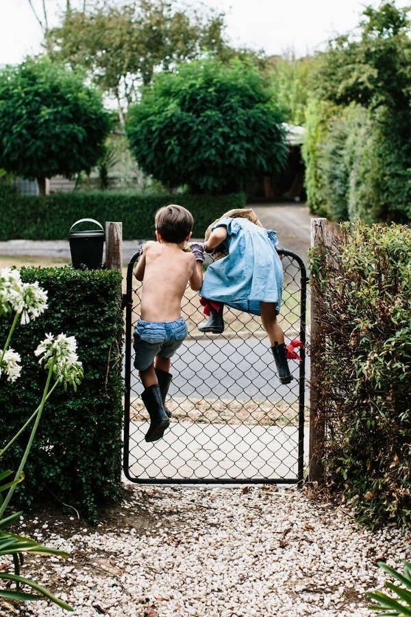 Deux enfants qui essayent de passer par dessus un portillon , comme une évasion 