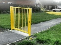 a single gate on a walking path with no surrounding fence of any kind