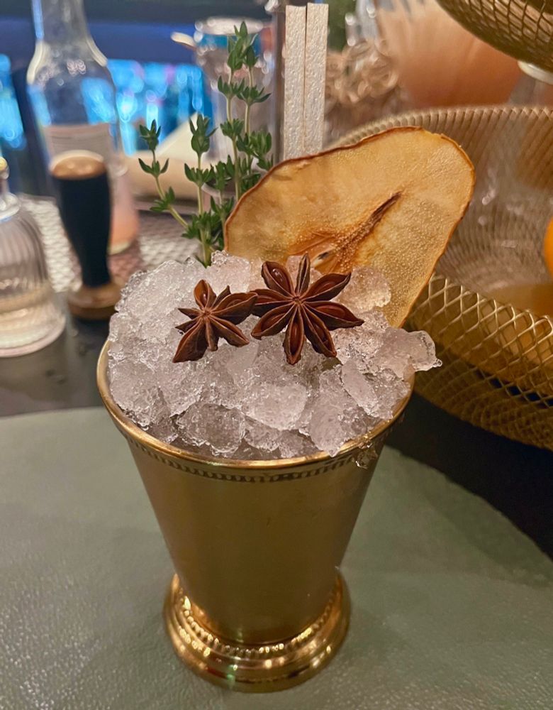on the wine bar of Emeril’s Restaurant, his flagship at 800 Tchoupitoulas St in New Orleans… a jerez cocktail on pebble ice garnished with a dehydrated pear, thyme sprigs, two star anise pods at NOLA’s first and only two Michelin Star Restaurant ⚜️