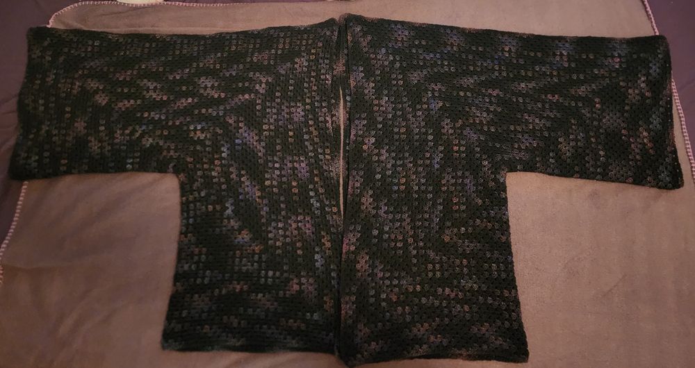 Black and purple crochet cardigan- the colorway zigzags randomly over the piece and there are small areas of blue, orange and pink with the purple.