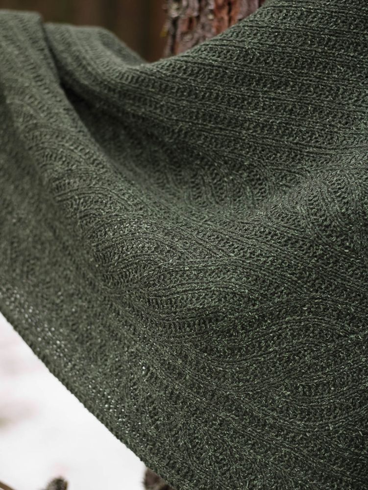 Close-up shot of a knit fabric with cable-like motifs in broken ribbing.