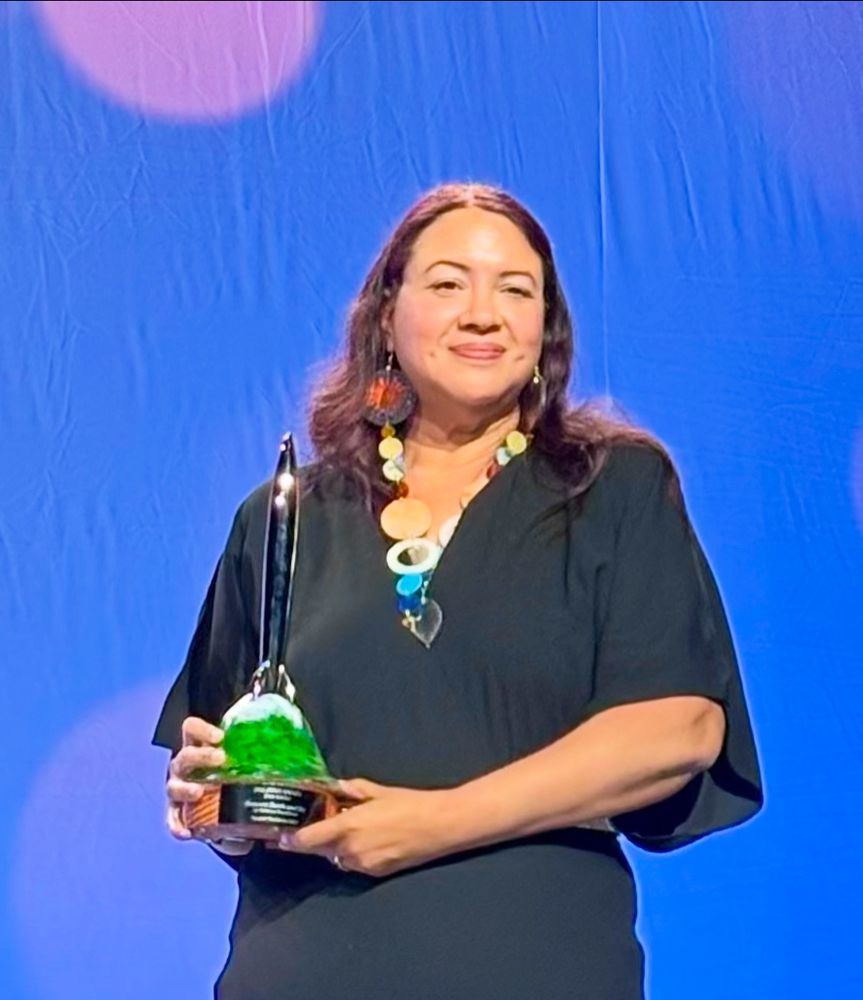 Rebecca Roanhorse (me!) holding the Hugo for Best Series. 