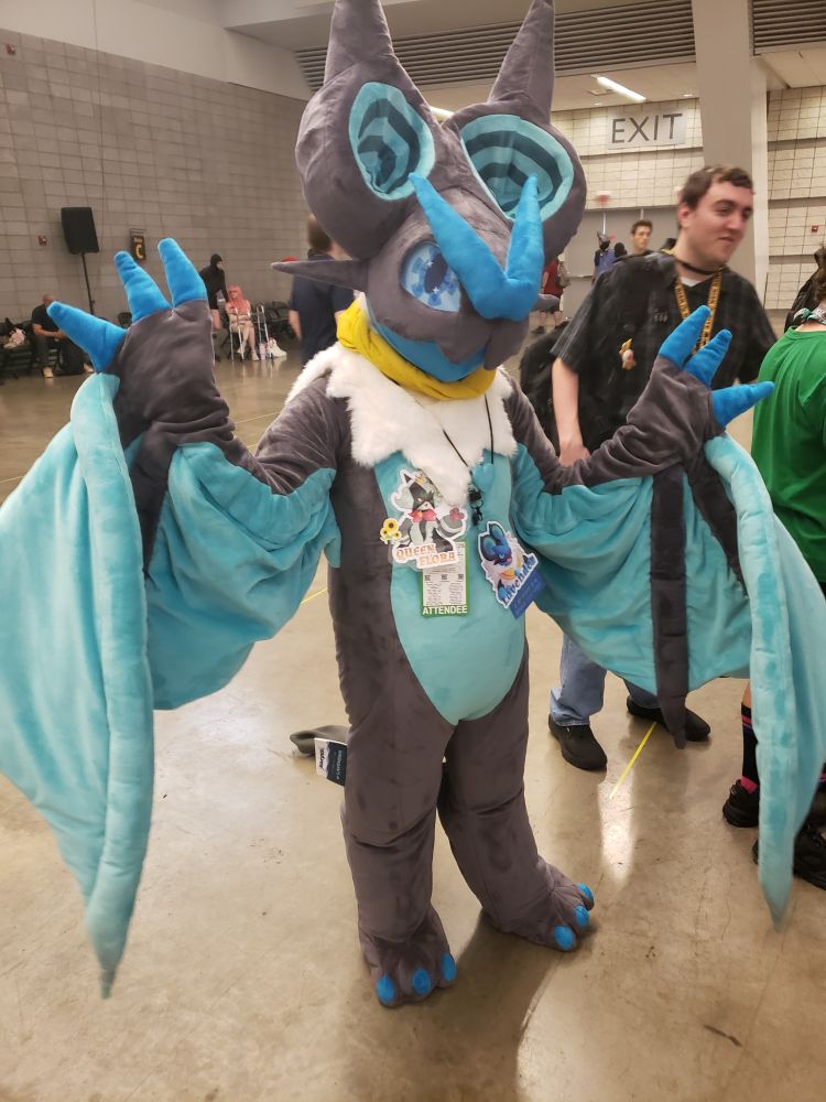 Queen Flora wearing their Lavender the Noivern fursuit at the Pokemon Meet & Greet event.