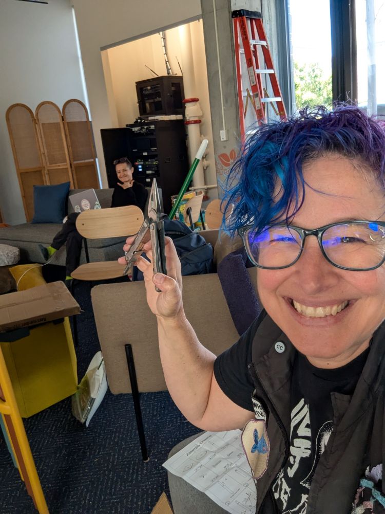Liz grinning while holding up a Leatherman tool