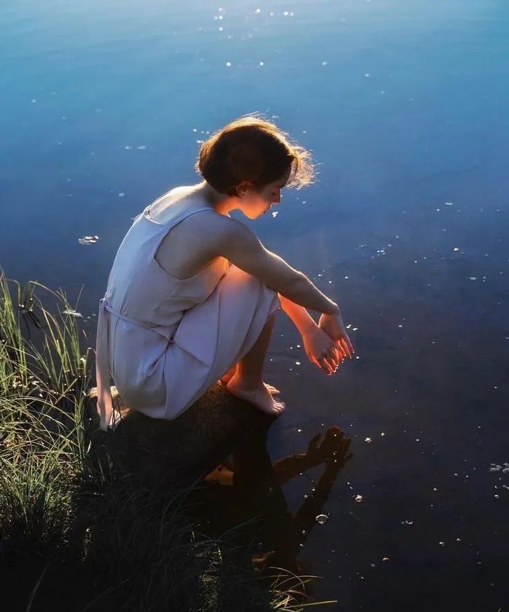 photo of a woman sitting in front of a body of water - i found it on pinterest and unfortunately cannot find the photographer anywhere to credit them