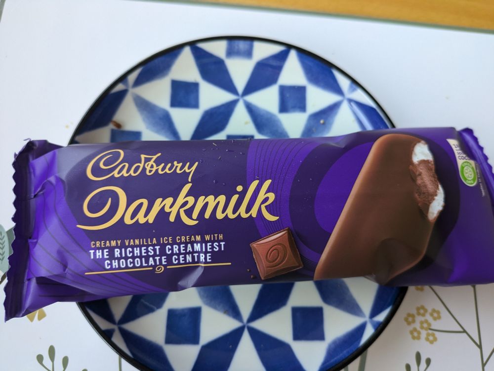 Cadbury Darkmilk ice cream in dark blue wrapper on blue and white plate
