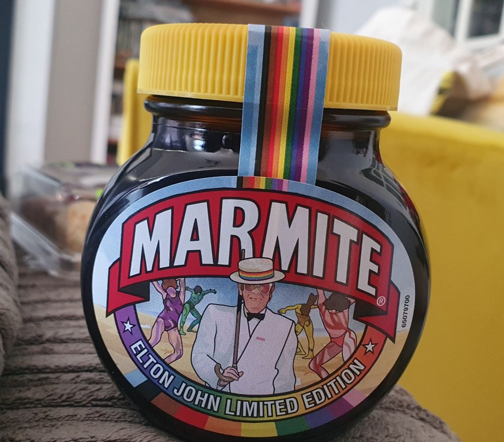 A jar of Marmite with a rainbow theme and a drawing of Elton John.