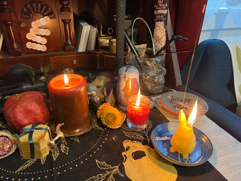 An altar with candles and incense alight.