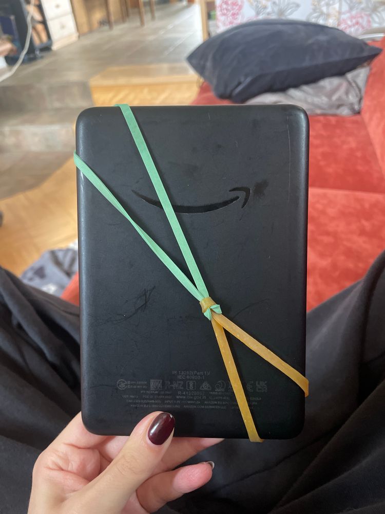 backside of my e-reader with two rubbers strained across 