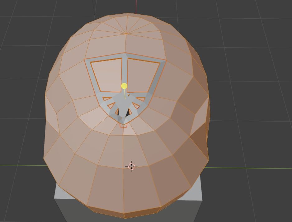 A back and top view of a helmet in progress on a cube. 

All of it is selected in orange except for a pattern that reminds the author of a shield with a pattern near the base. 