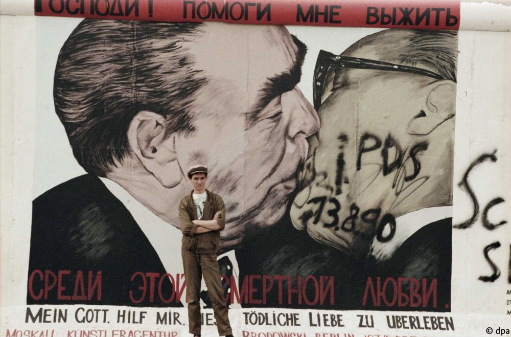 Soviet artist Dmitry Vrubel stands in front of his graffiti 'My God, Help Me to Survive This Deadly Love'.