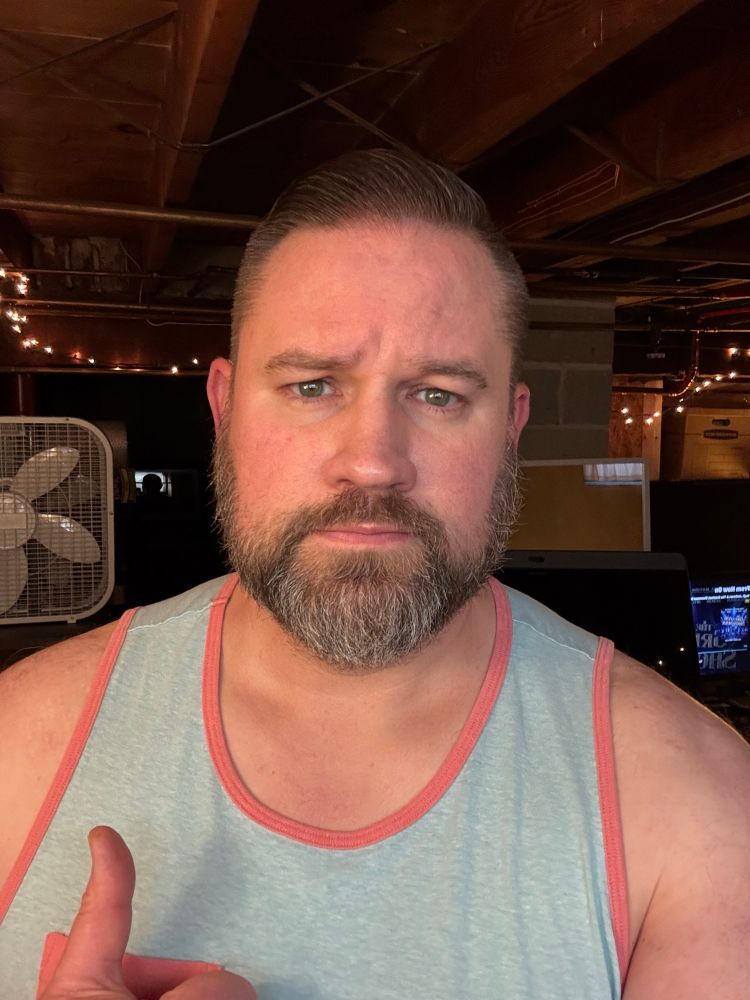 Another basement post-workout selfie, in a light blue tank top with pink trim.