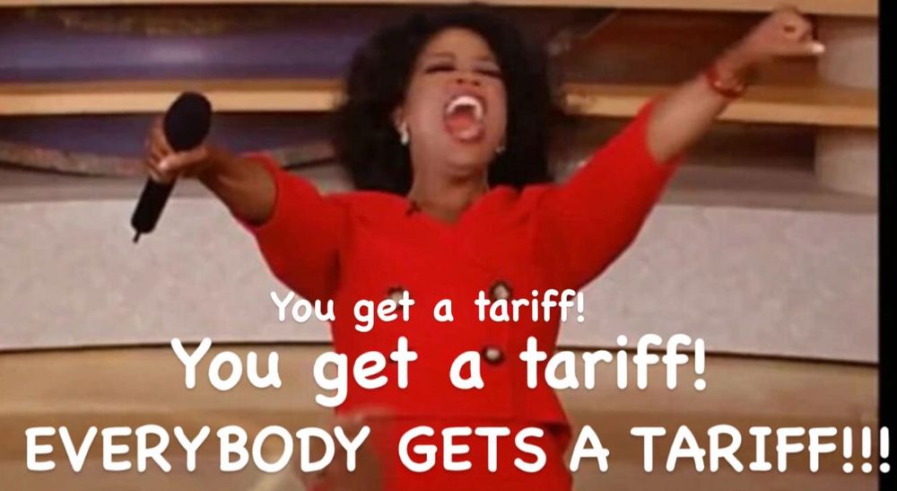An exuberant Oprah Winfrey, wearing a red suit with arms outstretched, hands out tariffs to all her audience members. 