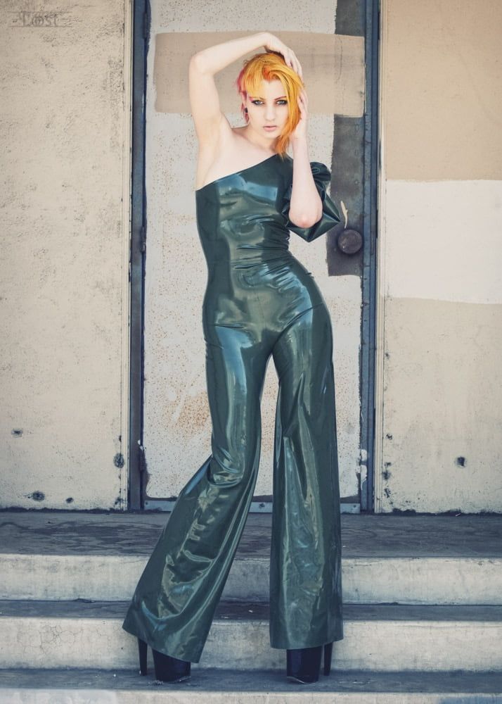 Photo of a woman wearing a latex jumpsuit standing on concrete steps