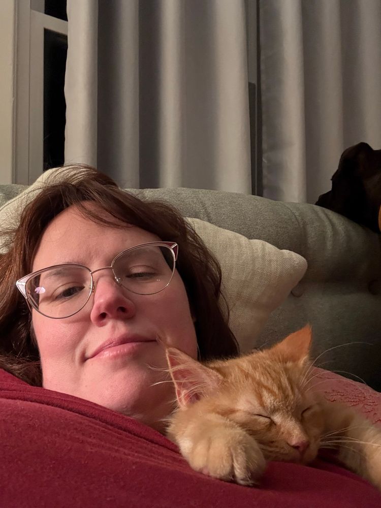 Ginger kitten sleeping on my shoulder but now his paws are extended 