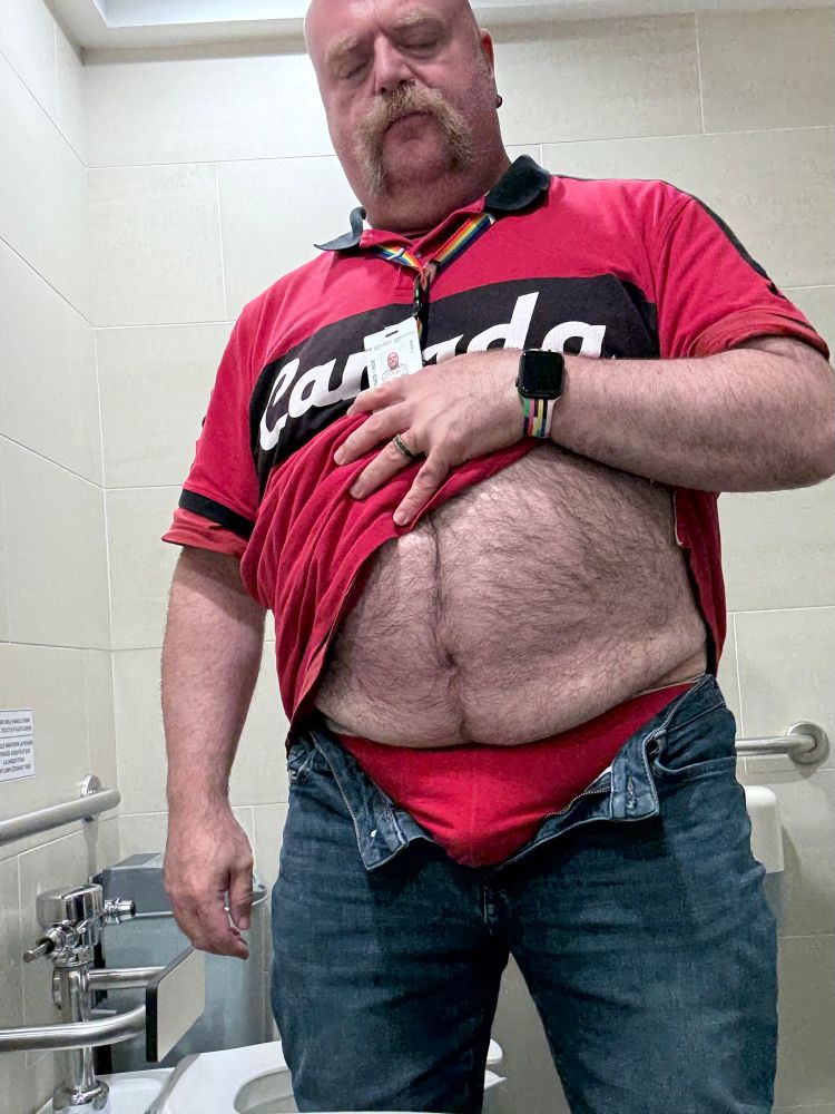 Man in washroom showing red underwear and shirt 