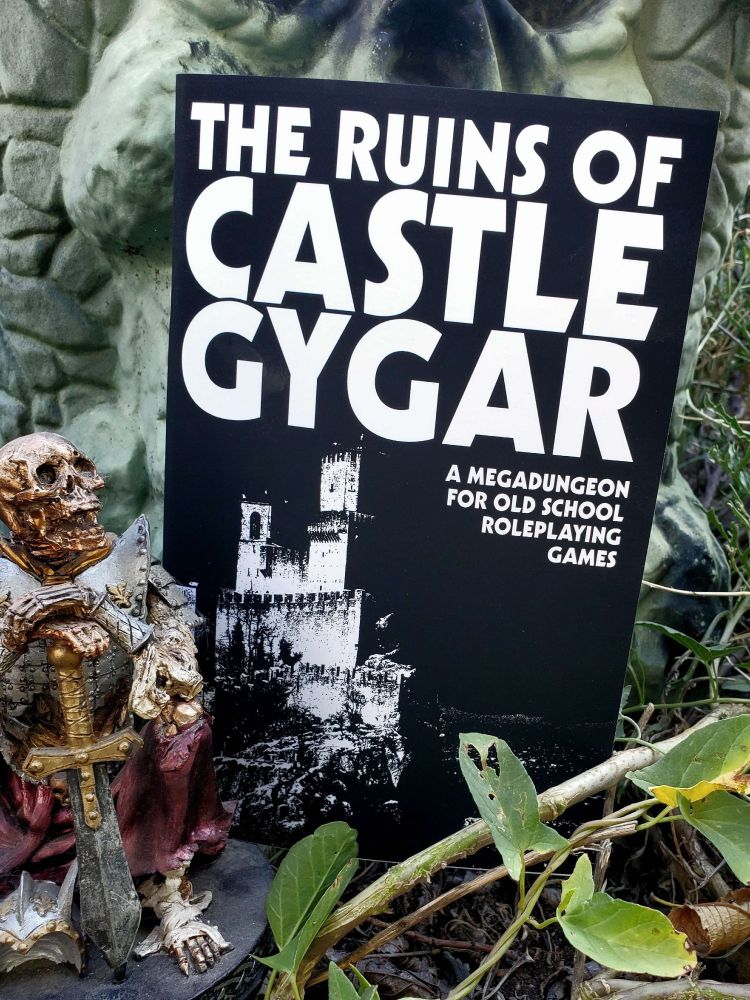 A book cover with the title 'THE RUINS OF CASTLE GYGAR,' in natural foliage and next to Castle Grayskull and a fuckin dope skeleton statue