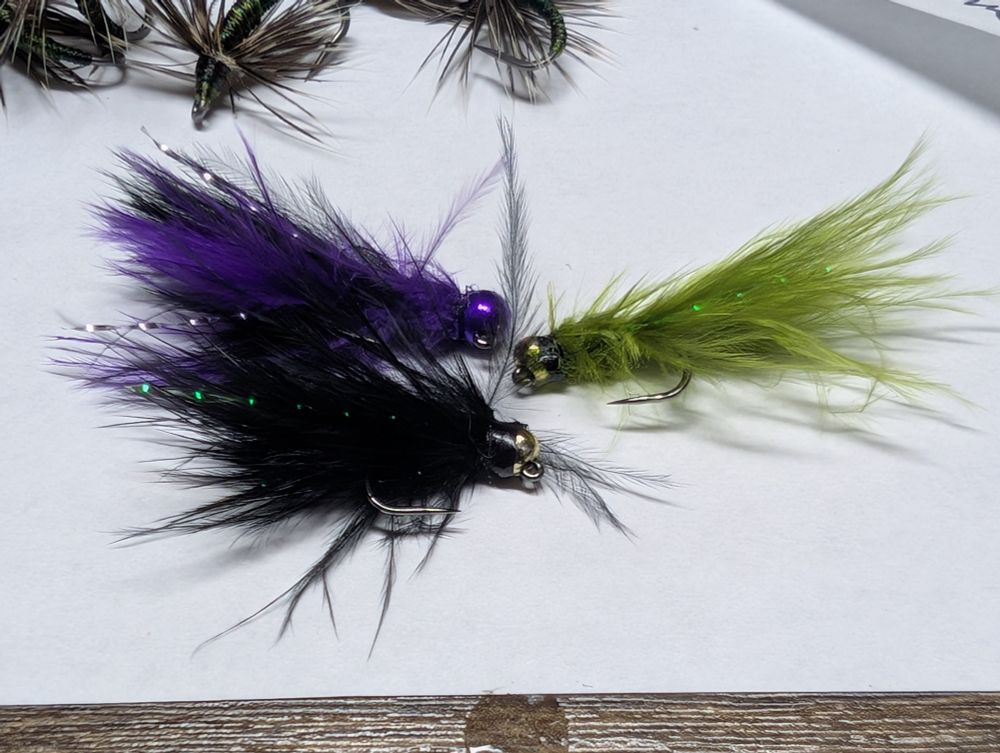 Three small Marabou bugger type flies in purple black and olive. 