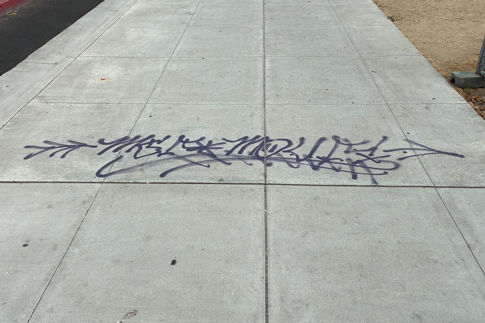 Graffiti-style signature on the wide sidewalk at Tele/22d. The same guy signed the new outdoor fixture at Kinfolx but the owner didn't like it.