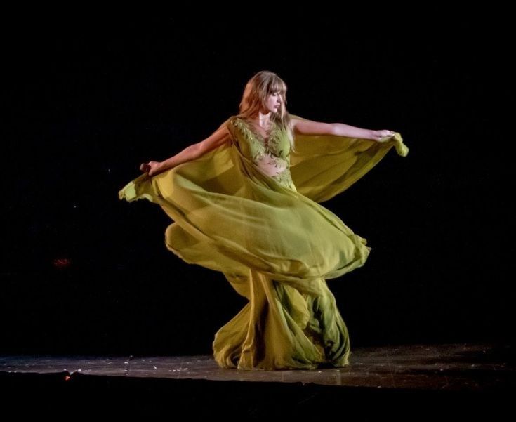 Taylor Swift in a green dress with leaves that seemed to give her a fairy vibe, dancing while performing the folklore set on her Eras Tour