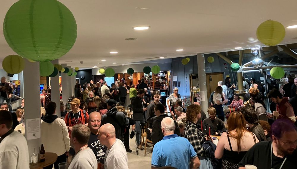 A crowd of people in a theatre foyer.