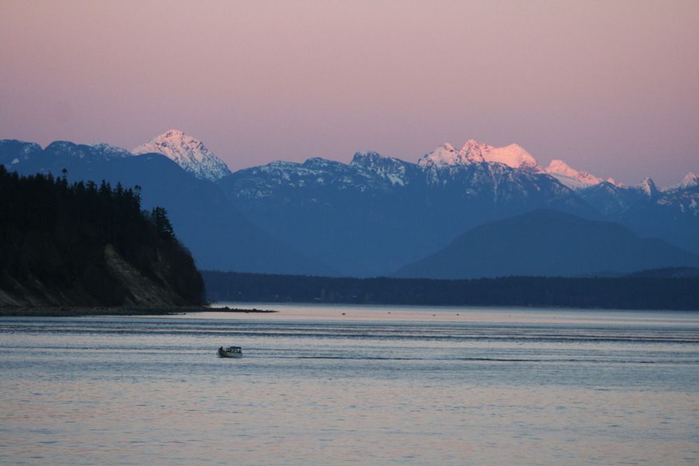 Sunset painting the Coast mountain range a pale pink with Cape Mudge to the left.  Picture taken from my balcony in Campbell River Bc