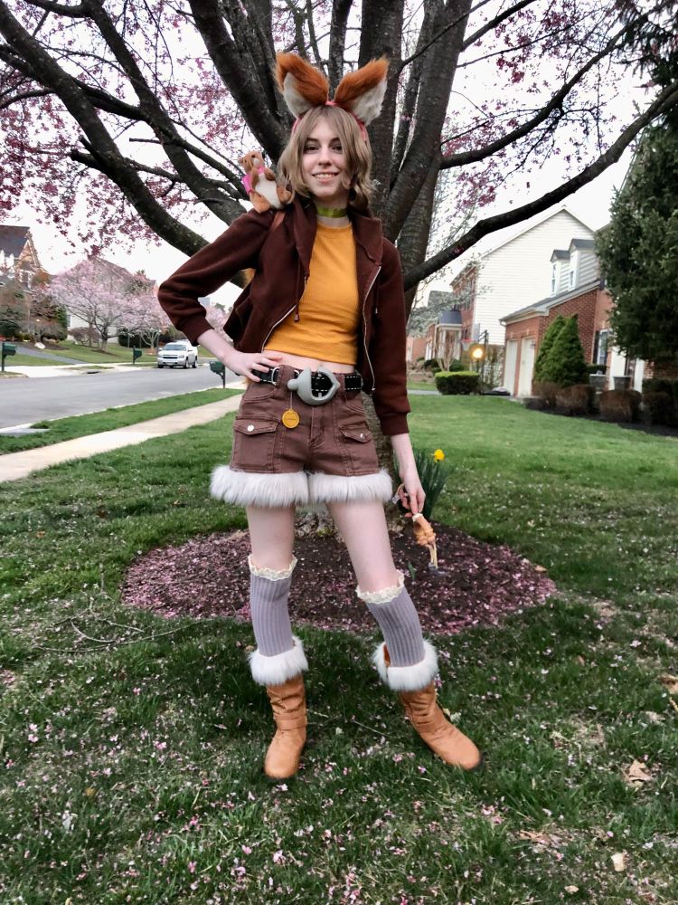 My daughter standing in front of a tree in her Squirrel Girl costume, holding a slingshot.