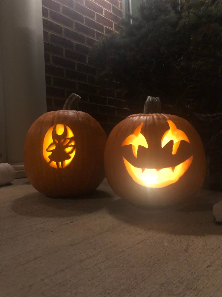 2 lit carved pumpkins, one of Hornet from Silksong, the other of Jevil from Delta Rune.
