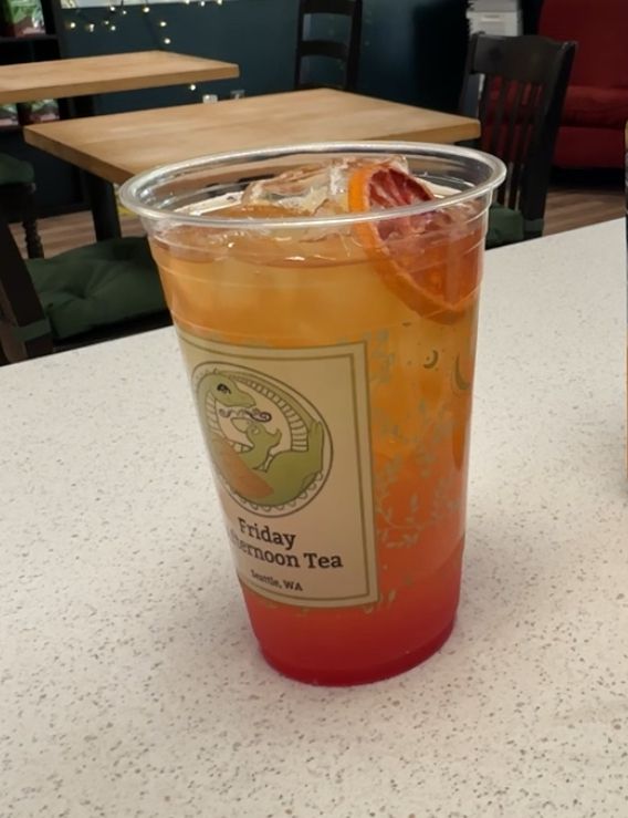 A yellow-to-red gradient mocktail on a tea house counter