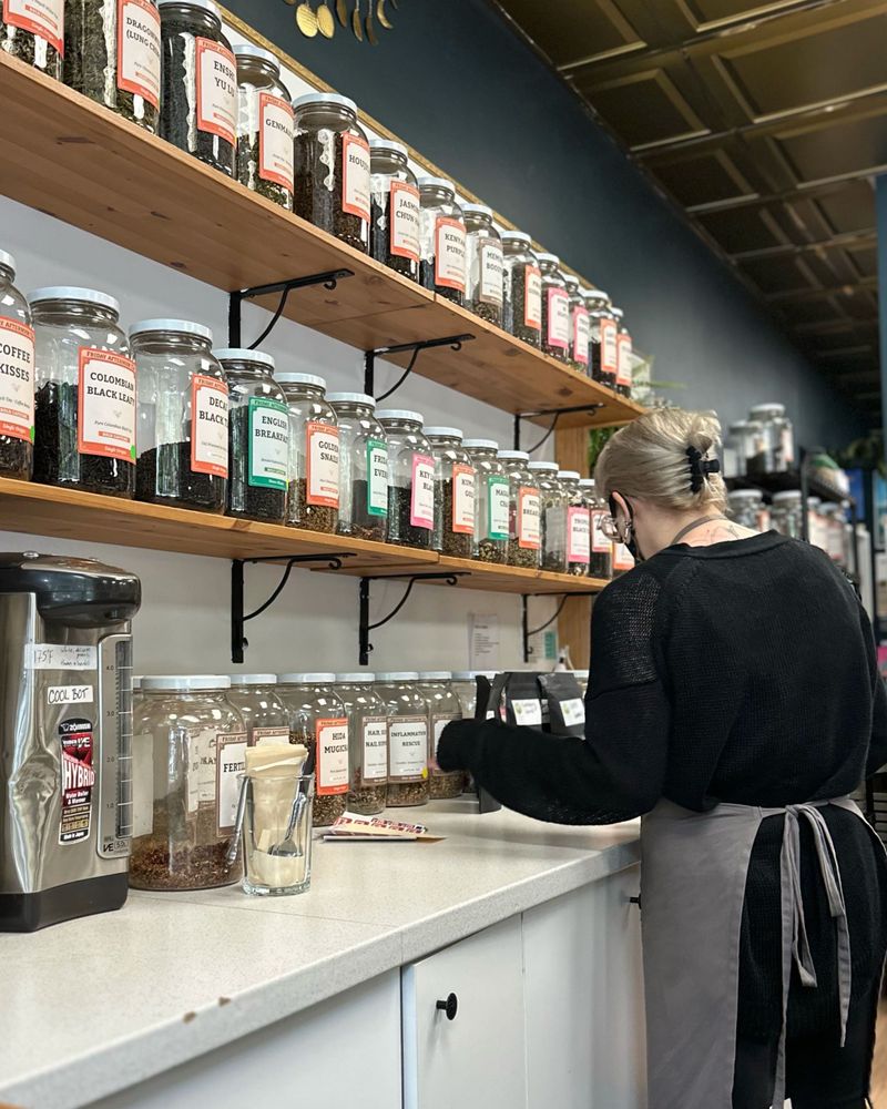 Kayla, a blonde tea server, packages tea behind the counter of a cafe