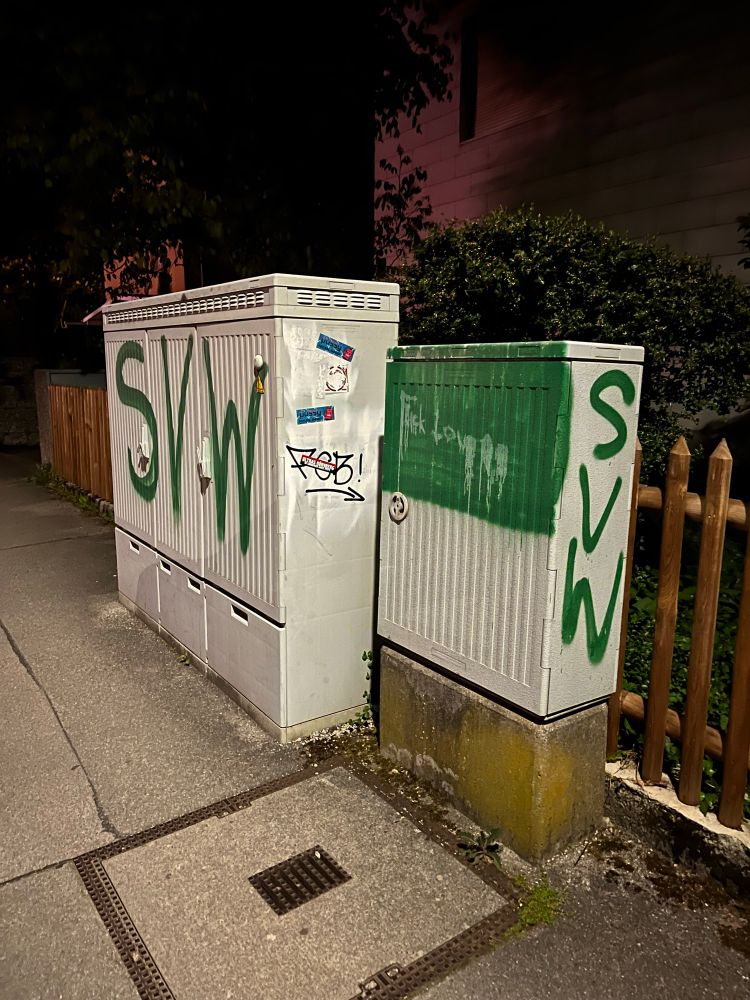 Zwei Verteilerkästen am Straßenrand. Der große Linke mit der Aufschrift „SVW“ über den ganzen Kasten und der Kleine auf der Rechten Seite ist von der Mitte nach oben in grün und nach unten in Weiß gefärbt. Auf der Seite ist ebenfalls ein „SVW“ Schriftzug. 