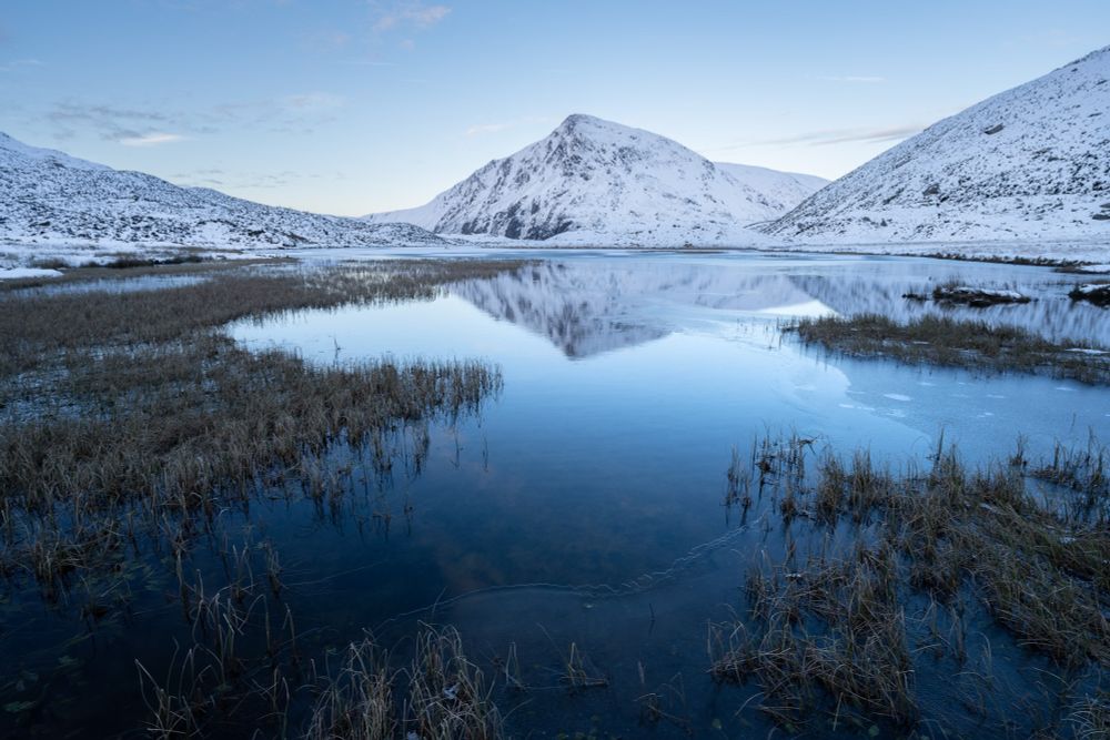 Snow covered mountains and a frozen lake in north wales 