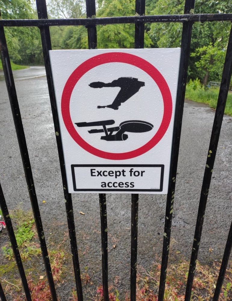 An except for access sign on a fence at the Botanics in Glasgow, except the picture depicts a constitution class starship and a Klingon bird of prey 