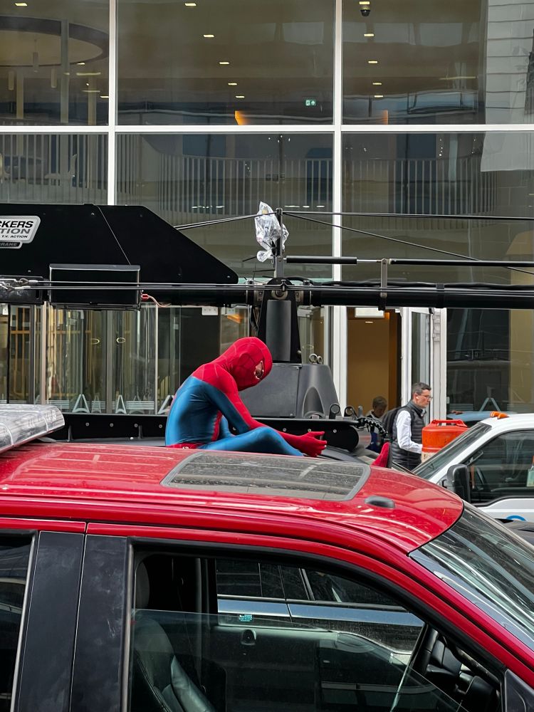 Not tom Holland sitting on a car roof preparing to rehearse a stunt on Bothwell St