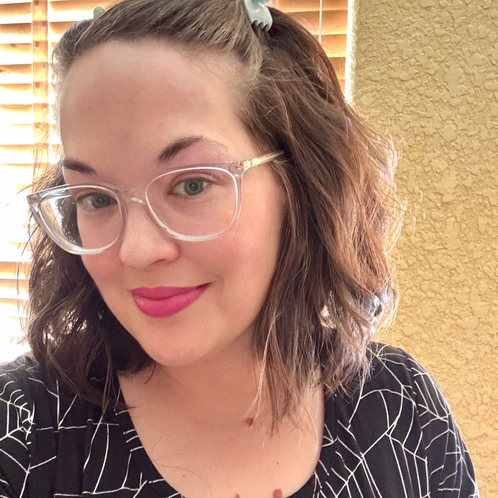 Selfie wearing a spider web dress and purple lipstick 