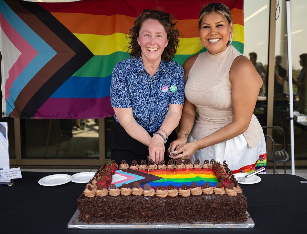 Two people cutting a Pride cake: (left) Nythalah Baker, Director, Equity, Diversity & Inclusion & Tee Copenace, Director of Indigenous Initiatives (right)
