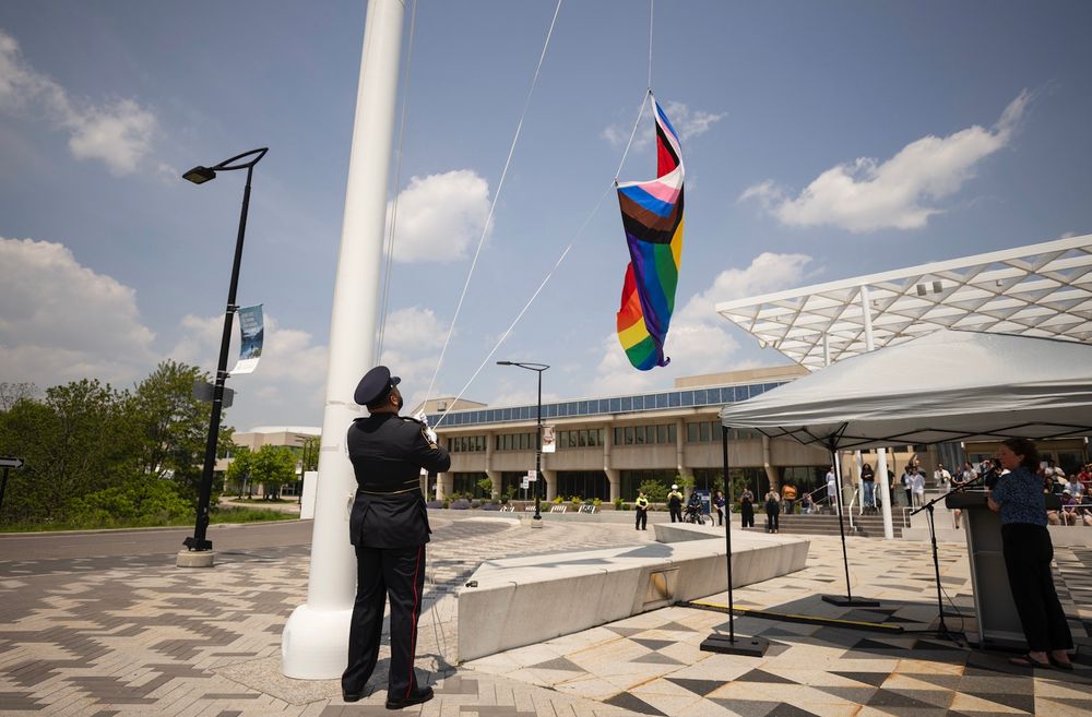Progress Pride flag being raised in front of Davis building