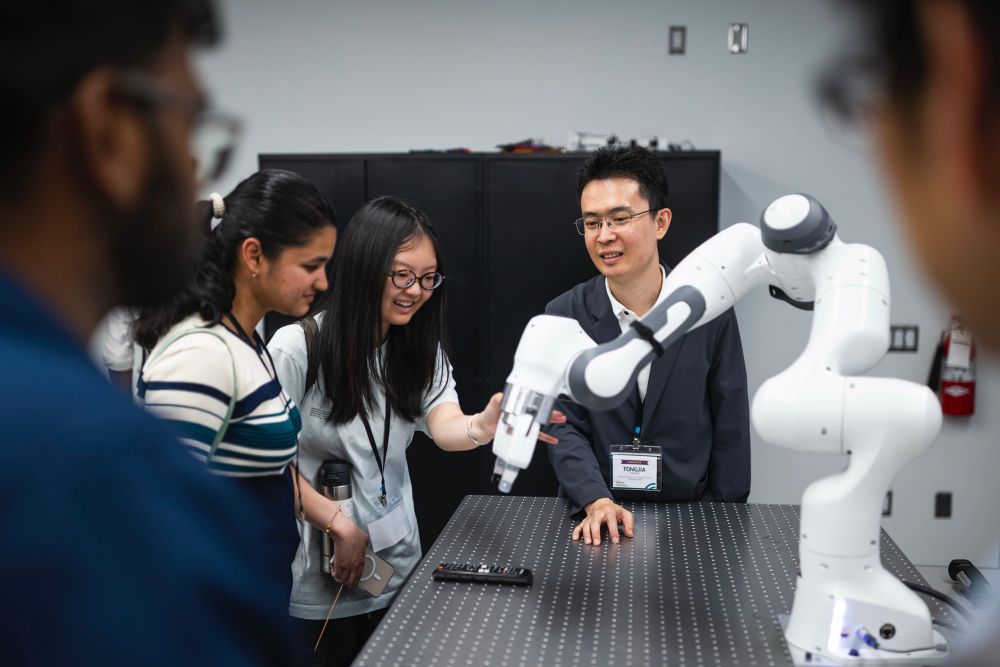 Visitors interact with a robotic arm in UTM’s Undergraduate Robotics Teaching Lab.


