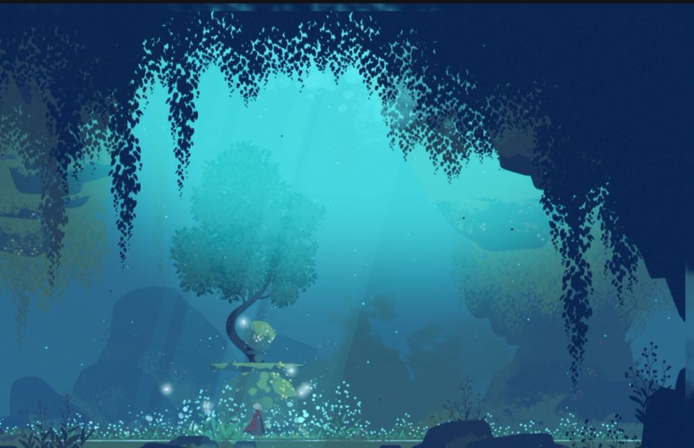 Screenshot of one of the early areas in Neva, a blue light from above is lighting a lush yet dimly lit forest area where a tree is at the centre. There are a few fireflies as well, the colours are mostly various blues and greens.