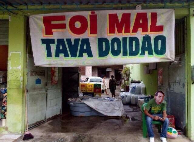 O 💩 sentado na cadeira em uma entrada e uma faixa acima dizendo "Foi mal, tava doidão"